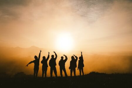 a group of young people facing the sun