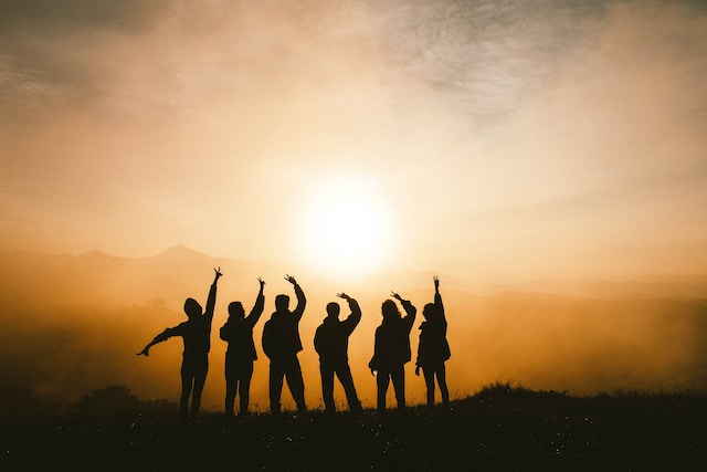 a group of young people facing the sun